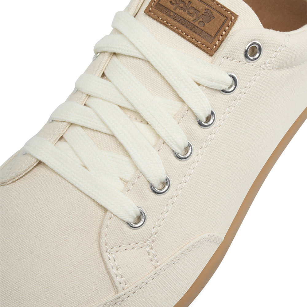 Close-up showing detail of the top and laces of the FREESTYLE 3 Almond sneaker , light tan with off white laces and a brown label on a white background