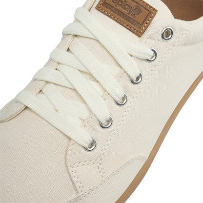 Close-up showing detail of the top and laces of the FREESTYLE 3 Almond sneaker , light tan with off white laces and a brown label on a white background