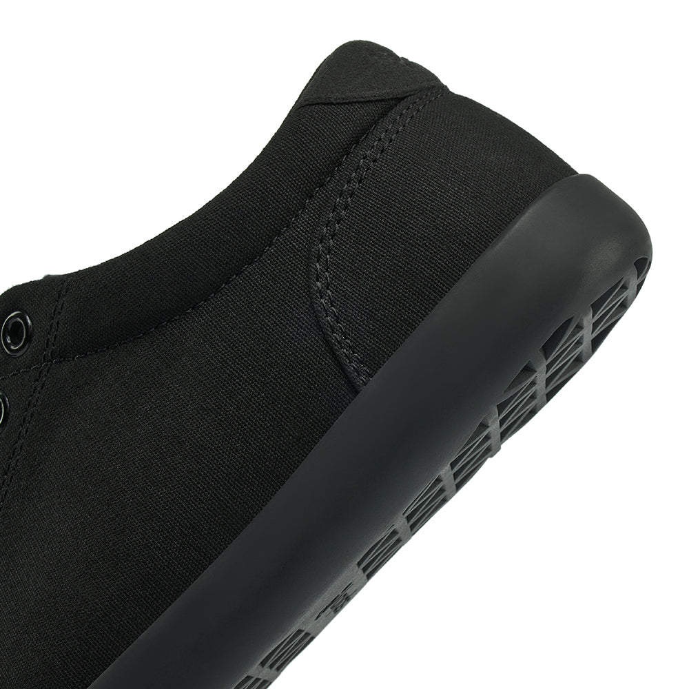Close up view of the back half of the FREESTYLE 3 Jet, Black sneaker with black eyelets and black accents on a white background
