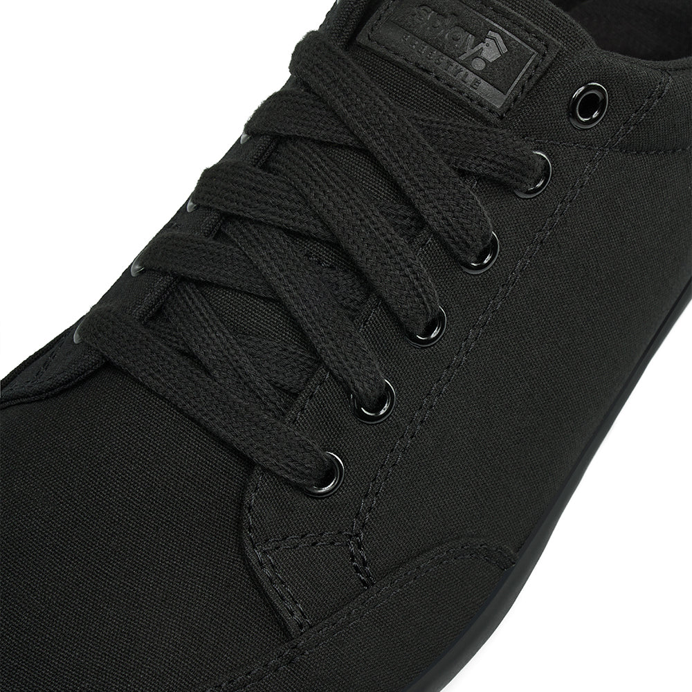 Close up view of the top and laces on the FREESTYLE 3 Jet, Black sneaker with black laces and black accents on a white background